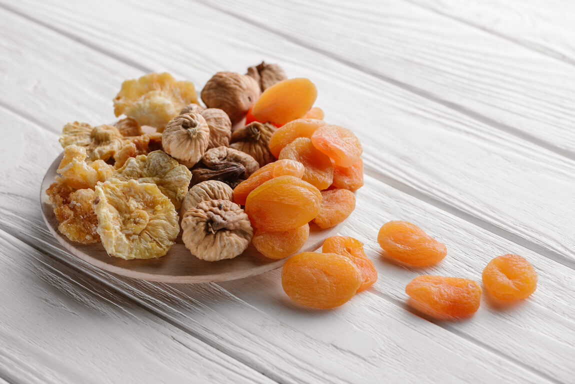 mixed-dried-fruits-on-white-plate-on-wooden-table-VQV5ED2